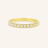 A gold half eternity band featuring a row of embedded white diamonds.
