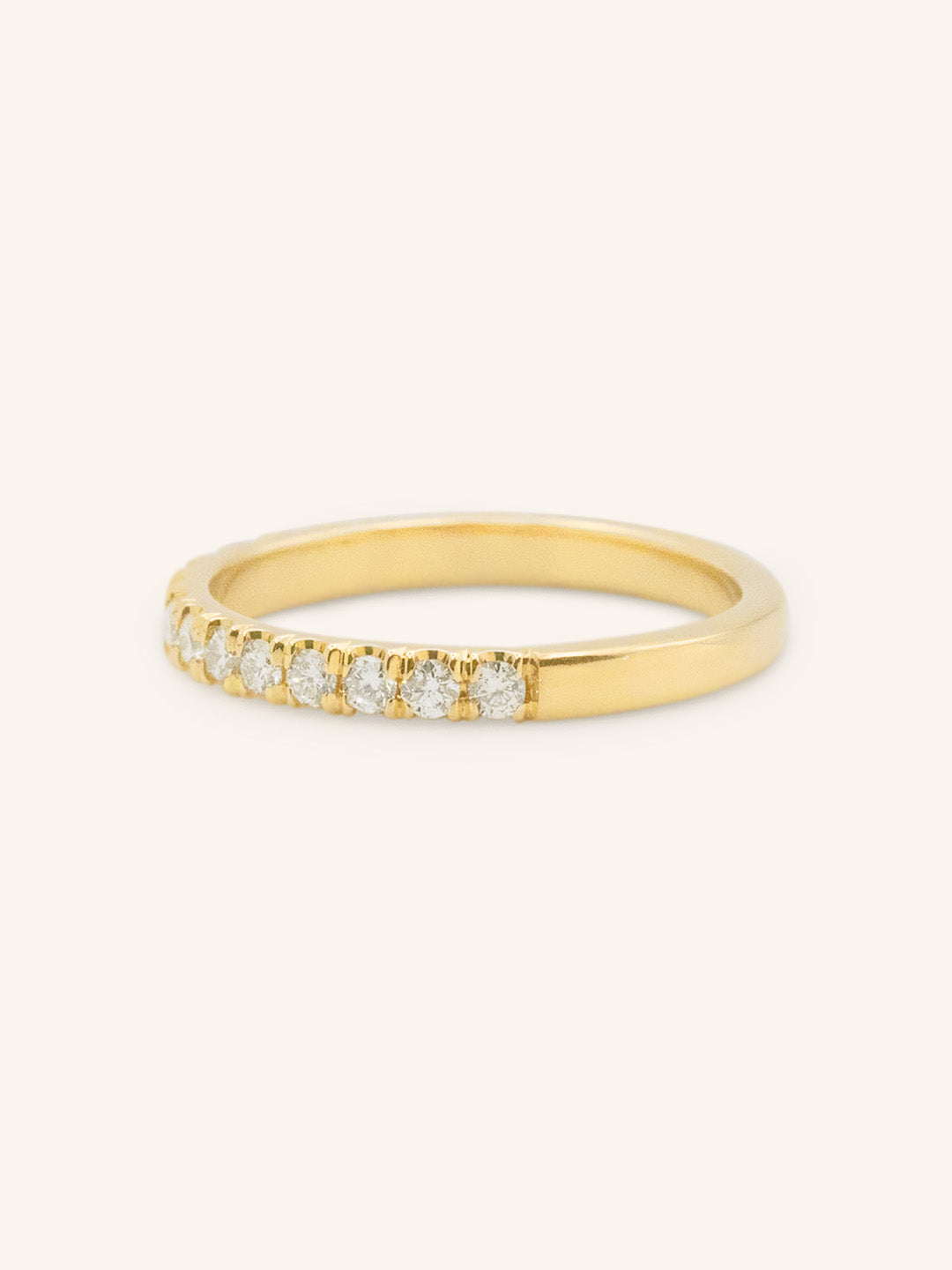 Gold ring with small diamonds on a white background