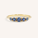 Yellow gold Lovett five stone blue sapphire anniversary ring front view on white background