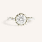 White gold round cut bezel set accented diamond engagement ring front view on white background