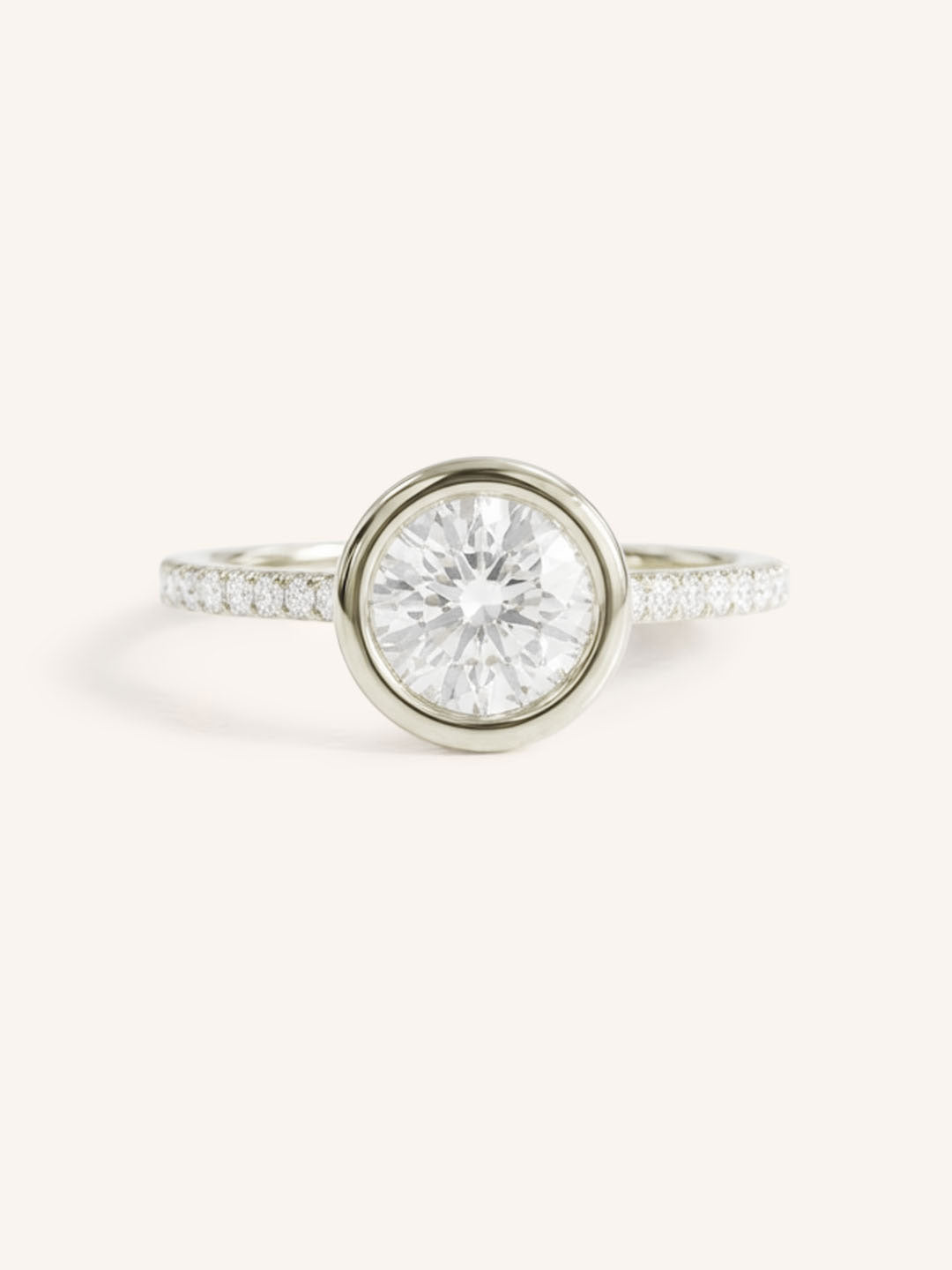 White gold round cut bezel set accented diamond engagement ring front view on white background