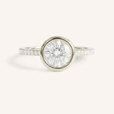 White gold round cut bezel set accented diamond engagement ring front view on white background