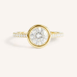 Yellow gold round cut bezel set accented diamond engagement ring front view on white background