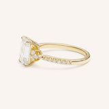 Yellow Gold emerald cut diamond engagement ring with pave band side view on white background