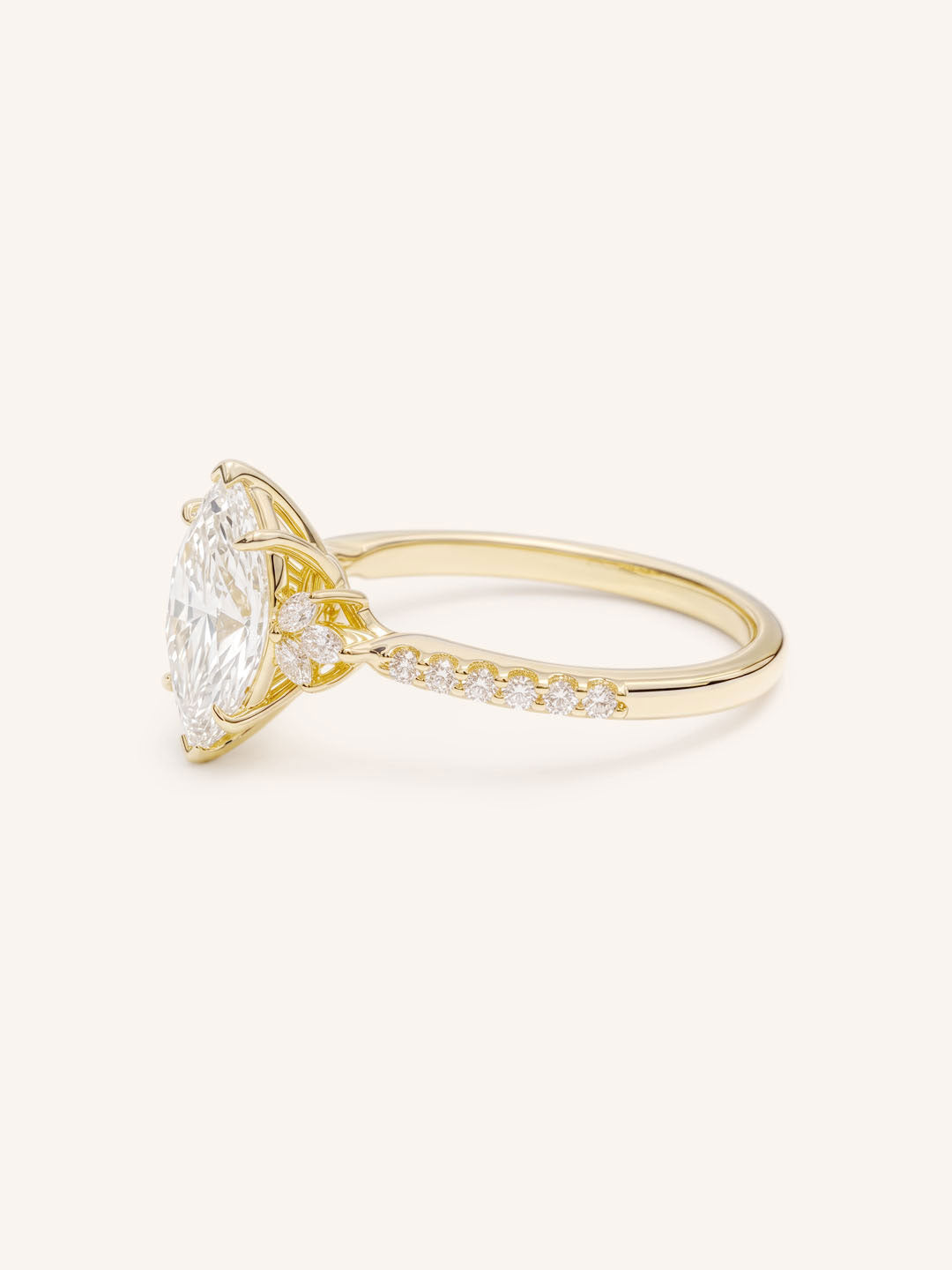 Yellow Gold marquise diamond engagement ring with pave band side view on white background