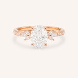 Rose gold oval-cut diamond engagement ring with marquise diamond accents on white background