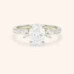 White gold oval-cut diamond engagement ring with marquise diamond accents on white background