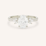 White gold oval-cut diamond engagement ring with marquise diamond accents on white background