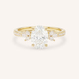 Yellow gold oval-cut diamond engagement ring with marquise diamond accents on white background