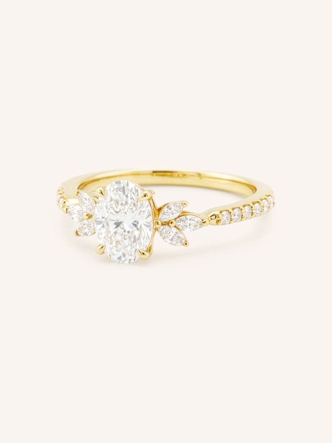 Yellow gold oval-cut diamond engagement ring with marquise diamond accents, angled view on white background