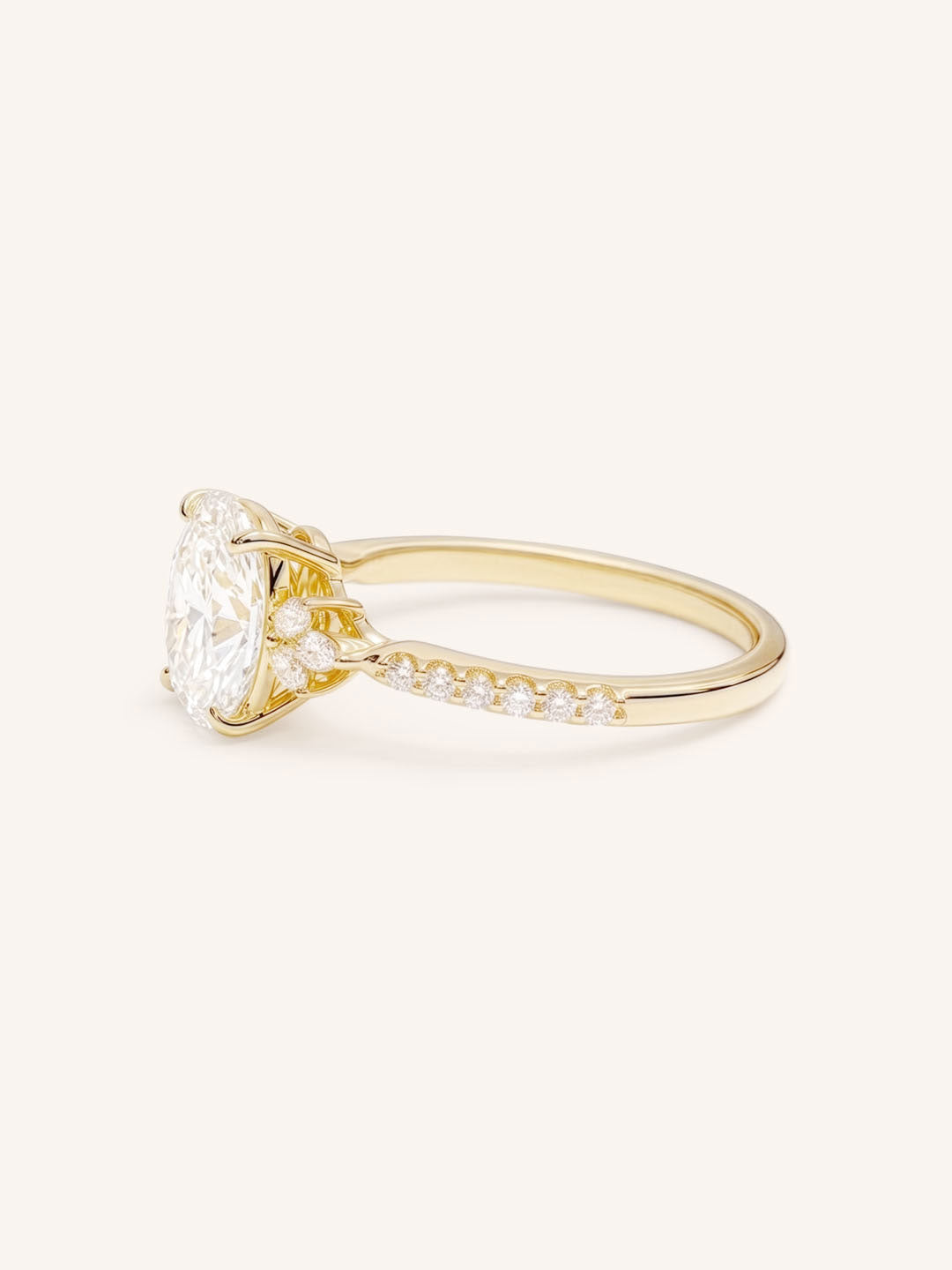Yellow Gold oval diamond engagement ring with pave band side view on white background