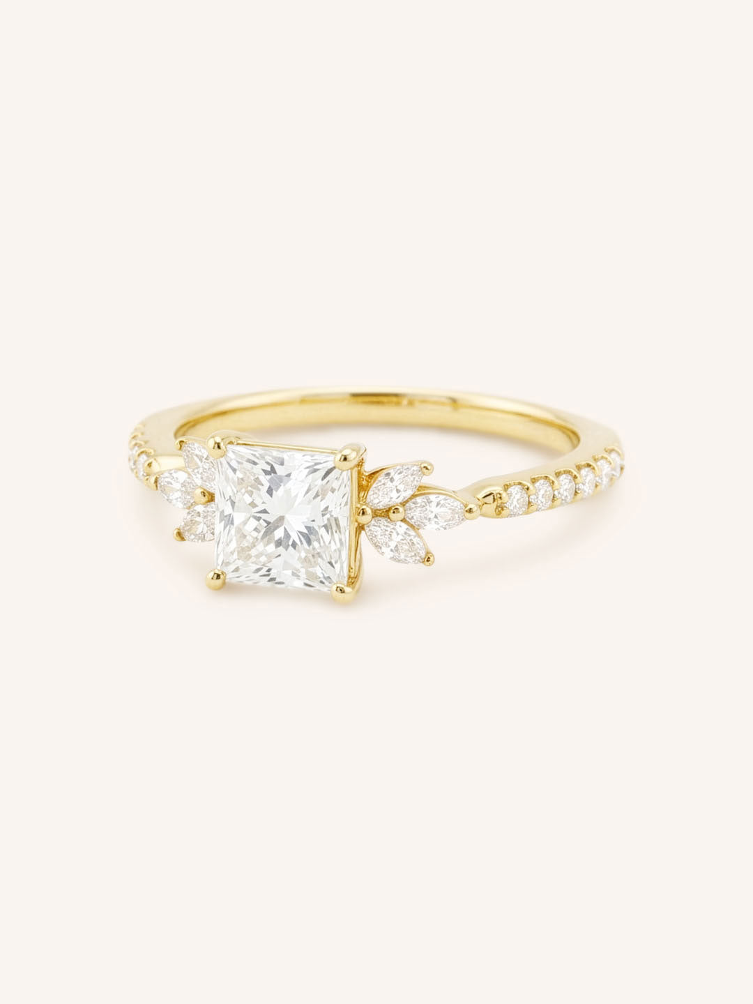 Yellow gold princess-cut diamond engagement ring with marquise diamond accents, angled view on white background
