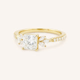 Yellow gold princess-cut diamond engagement ring with marquise diamond accents, angled view on white background