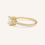 Yellow gold princess-cut diamond engagement ring with pavé band, side view on white background