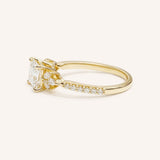 Yellow gold princess-cut diamond engagement ring with pavé band, side view on white background
