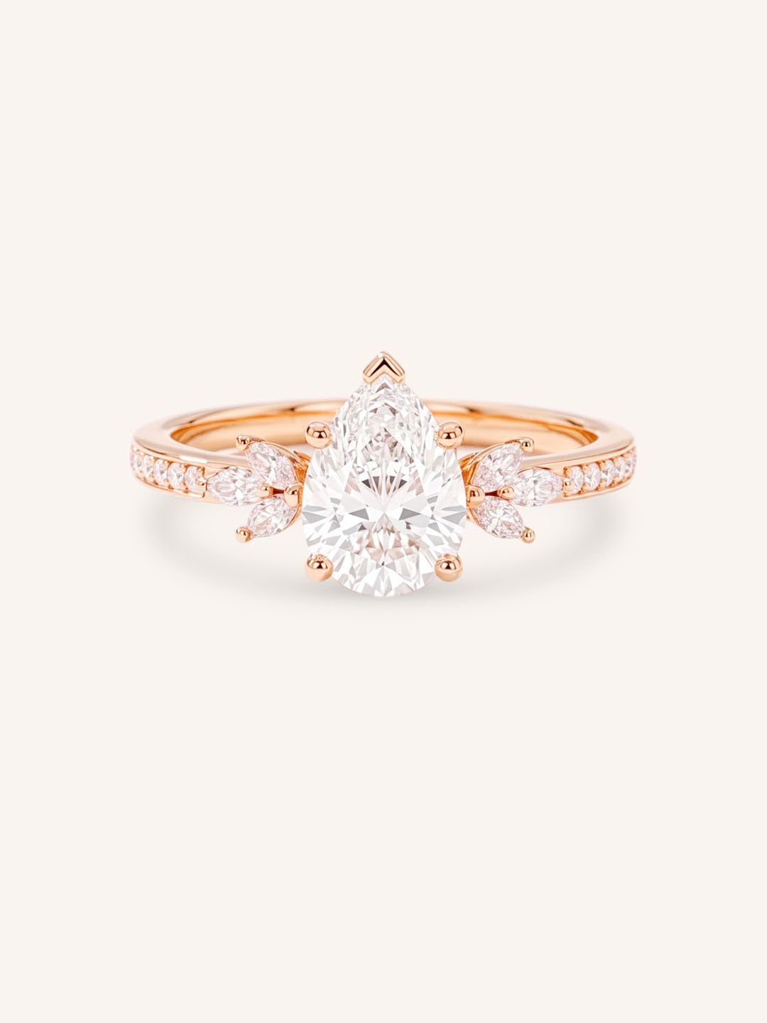 Rose gold pear-cut diamond engagement ring with leaf-shaped diamond accents on the band, front view on white background