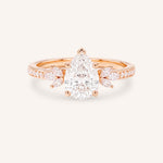 Rose gold pear-cut diamond engagement ring with leaf-shaped diamond accents on the band, front view on white background