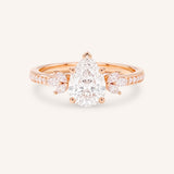 Rose gold pear-cut diamond engagement ring with leaf-shaped diamond accents on the band, front view on white background