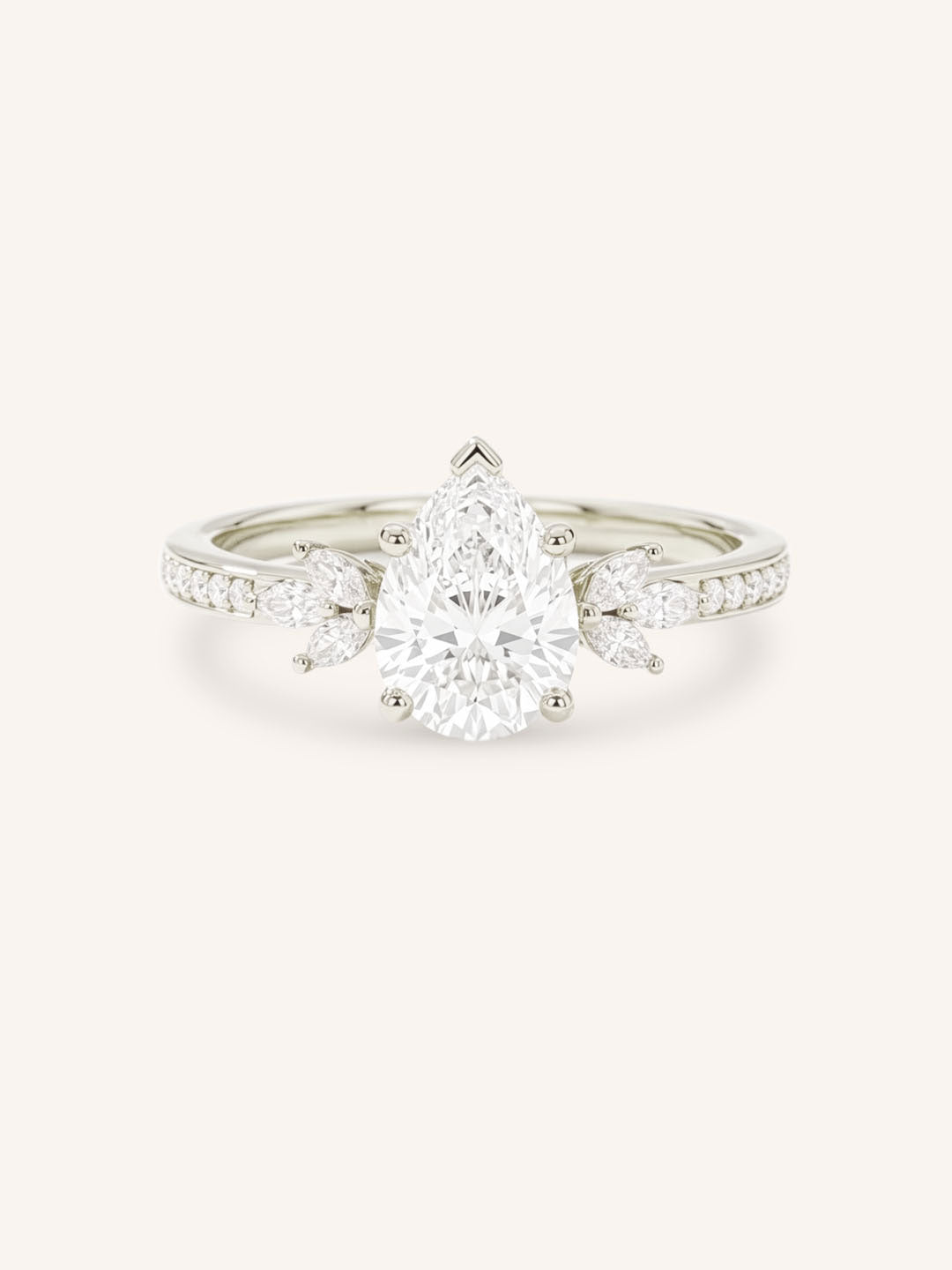 White gold pear-cut diamond engagement ring with leaf-shaped diamond accents on the band, front view on white background