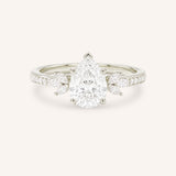 White gold pear-cut diamond engagement ring with leaf-shaped diamond accents on the band, front view on white background