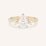Yellow gold pear-cut diamond engagement ring with leaf-shaped diamond accents on the band, front view on white background