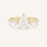 Yellow gold pear-cut diamond engagement ring with leaf-shaped diamond accents on the band, front view on white background