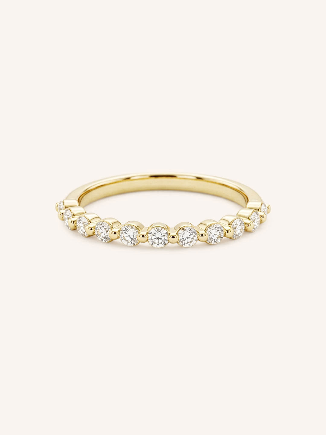 Yellow gold eternity wedding ring with a row of round diamonds, full band view, on white background