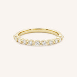 Yellow gold eternity wedding ring with a row of round diamonds, full band view, on white background