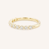 Yellow gold wedding ring with a row of graduated round diamonds in prong settings, side view, on white background