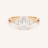 Rose gold Lindey emerald-cut three-stone diamond engagement ring with pave shoulders, front view, on white background