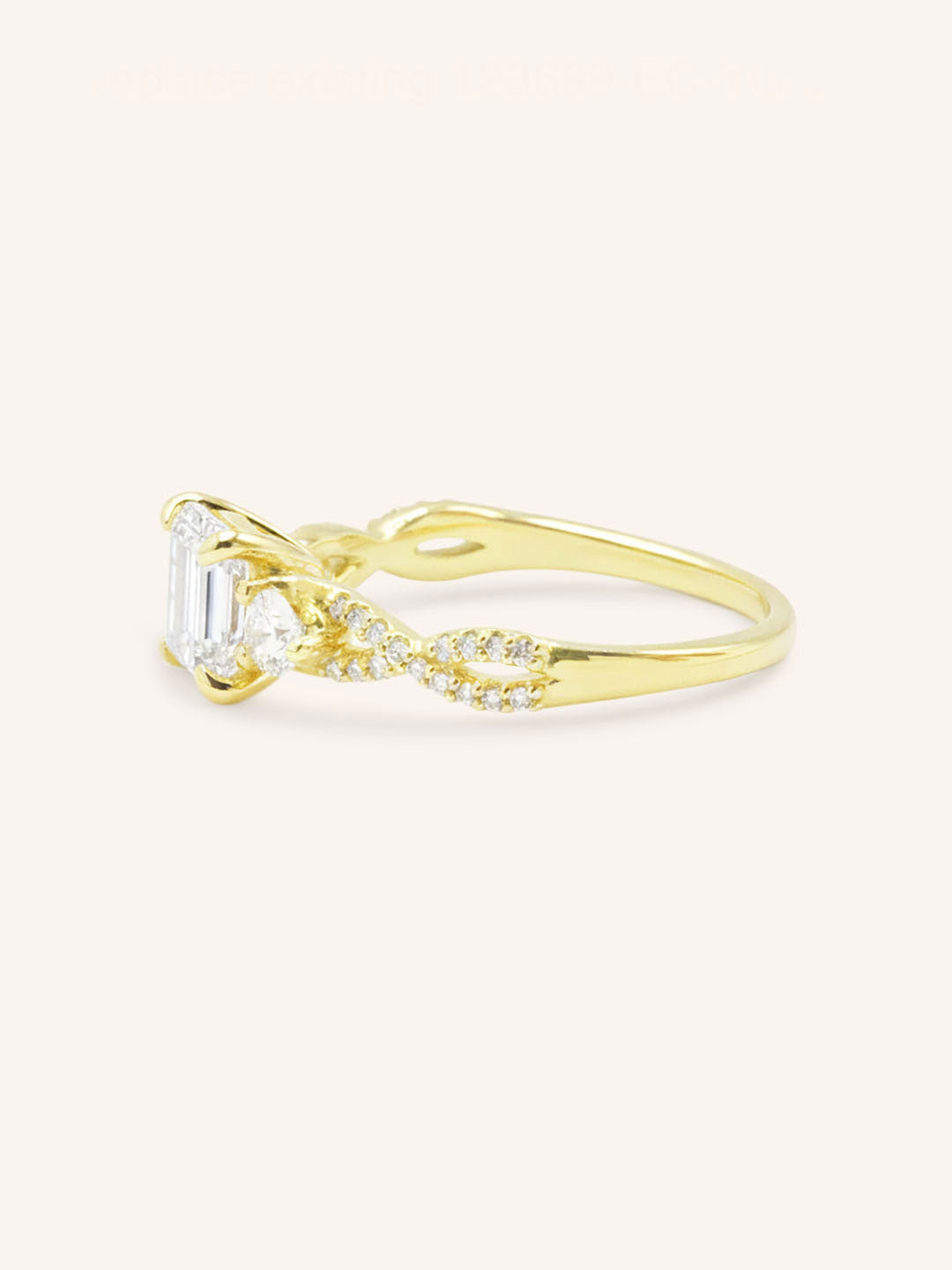 Yellow gold Lindey emerald cut three stone diamond engagement ring side view on white background