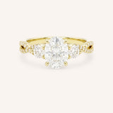 Yellow gold three-stone engagement ring with oval-cut center diamond, round side diamonds, and twisted pave diamond shank, front view, on white background