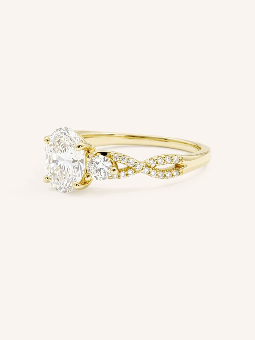Yellow gold three-stone engagement ring with oval-cut center diamond and twisted pave diamond shank, side view, on white background