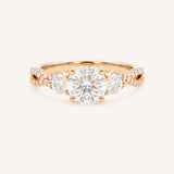 Rose gold Lindey round three-stone diamond engagement ring with pave shoulders, front view, on white background