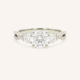 White gold round cut three stone diamond engagement ring with pave shoulders on white background