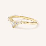 Yellow gold curved wedding band with pear-cut diamond and graduated round diamond accents on white background