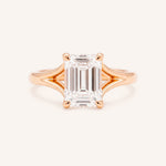 Rose Gold emerald cut diamond split shank engagement ring on white background