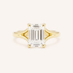 Yellow Gold emerald cut diamond split shank engagement ring on white background