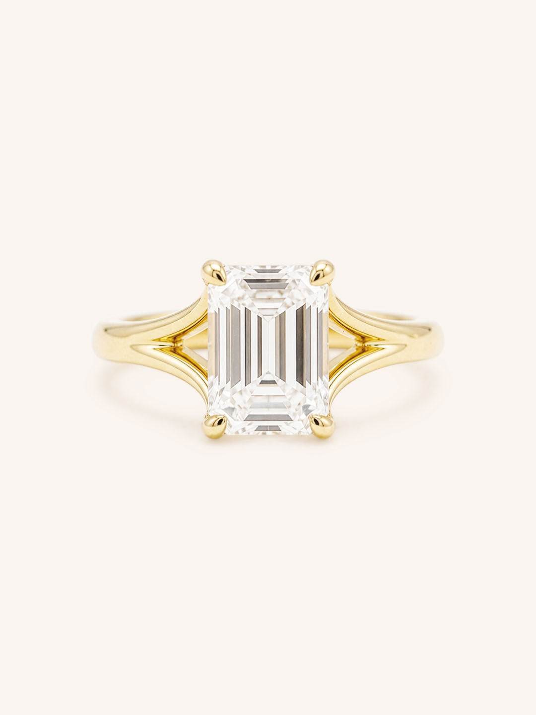 Yellow Gold emerald cut diamond split shank engagement ring on white background