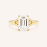 Yellow Gold emerald cut diamond split shank engagement ring on white background