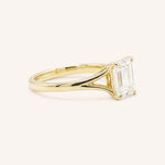 Yellow Gold emerald cut diamond split shank engagement ring side view on white background