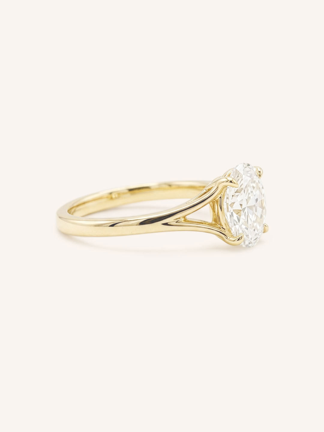 Yellow Gold oval diamond split shank engagement ring side view on white background