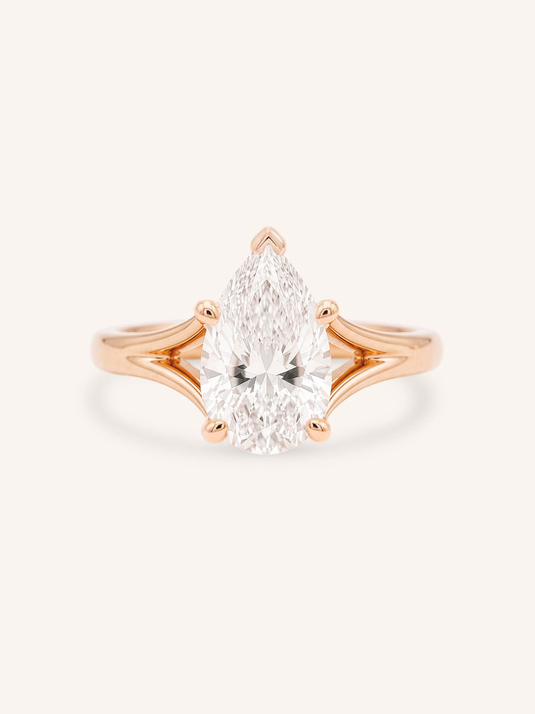 Rose Gold pear cut diamond split shank engagement ring on white background