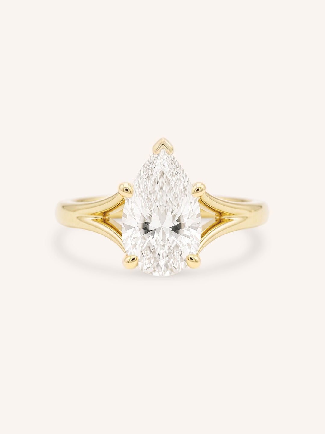 Yellow Gold pear cut diamond split shank engagement ring on white background