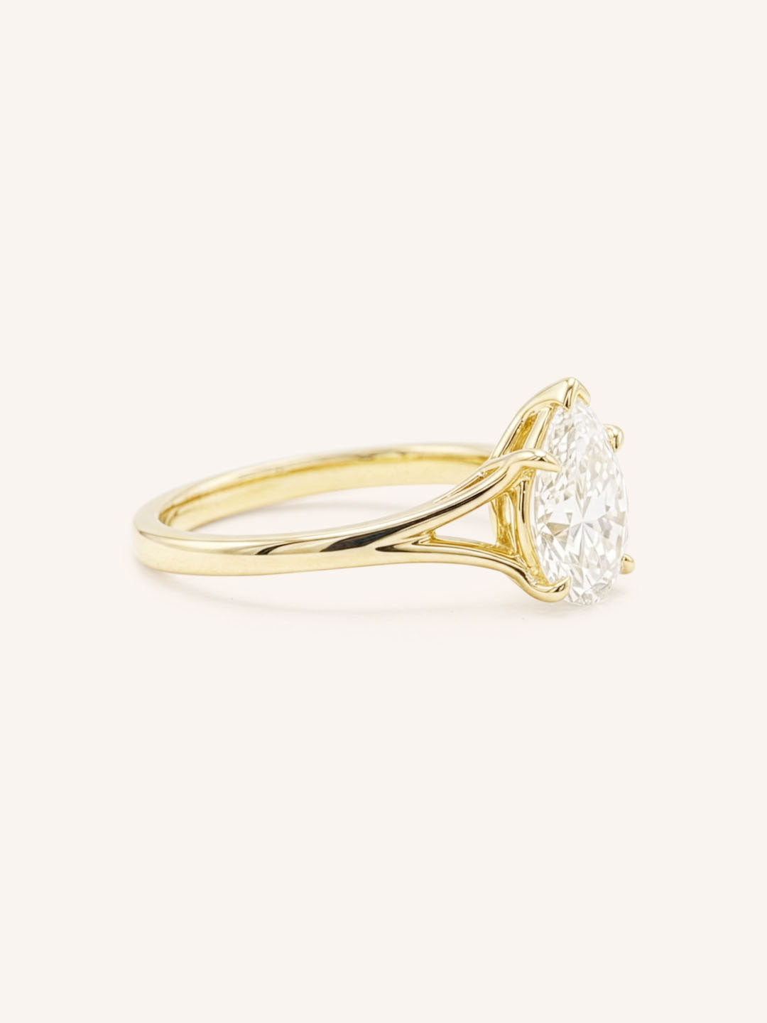 Yellow Gold pear cut diamond split shank engagement ring side view on white background