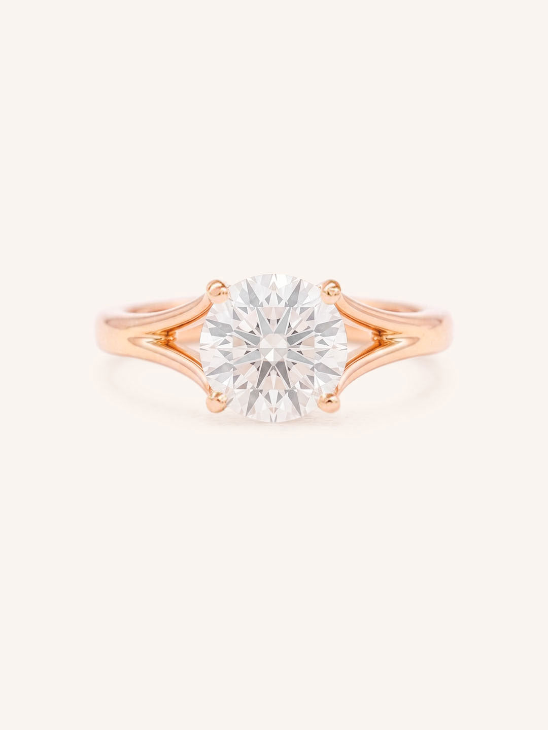 Rose Gold round diamond split shank engagement ring on white background