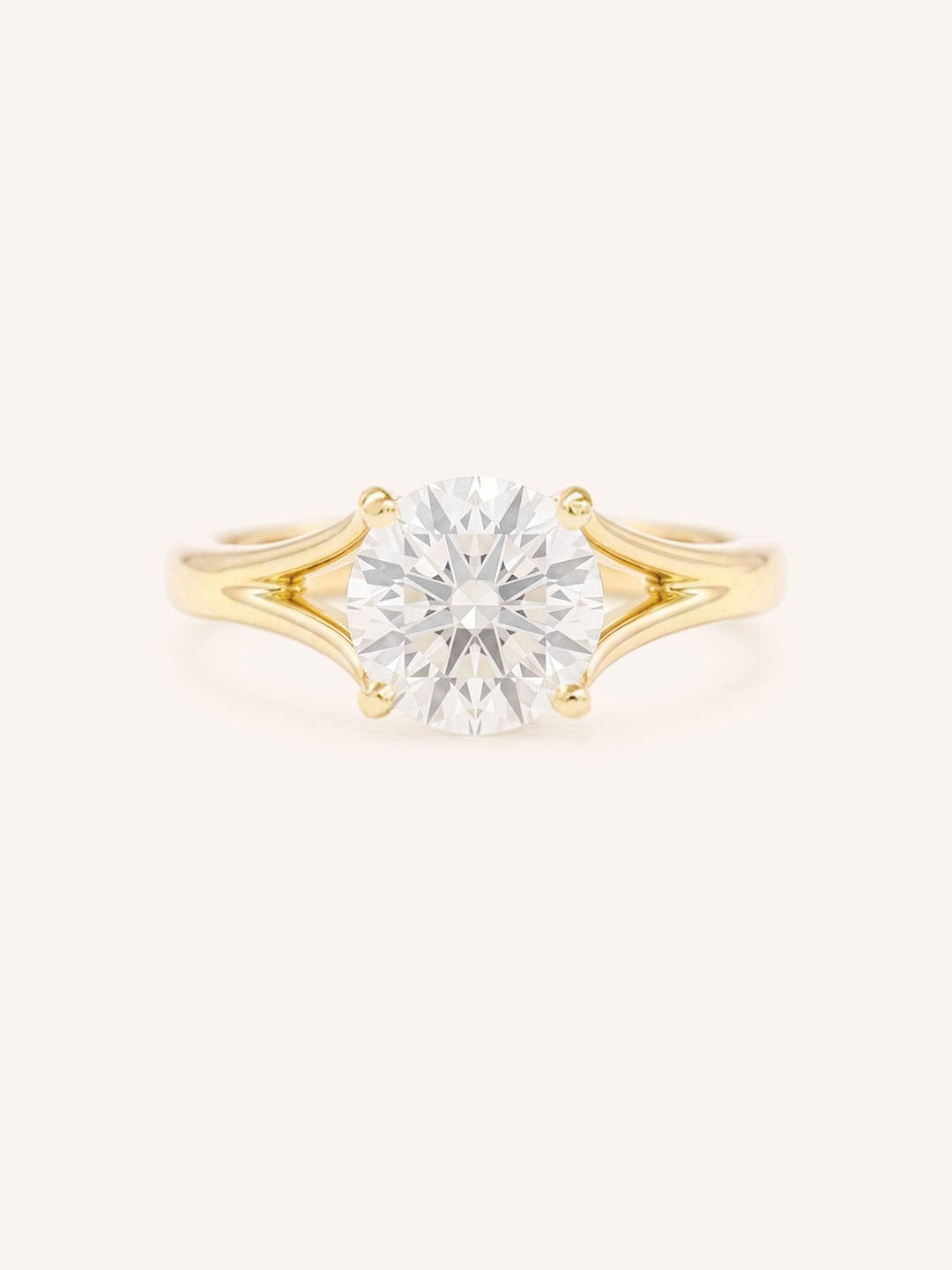 Yellow Gold round diamond split shank engagement ring on white background