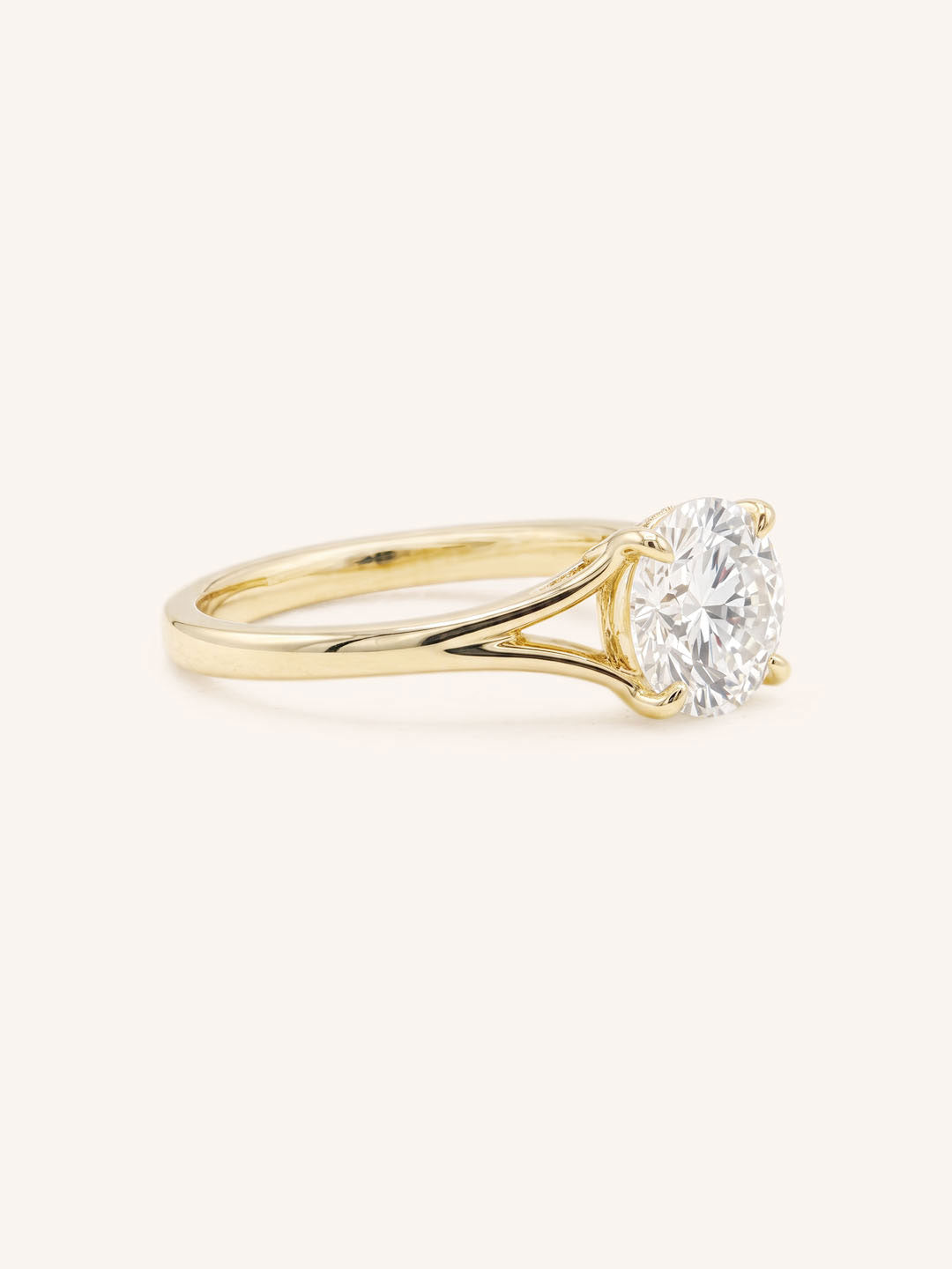Yellow Gold round diamond split shank engagement ring side view on white background