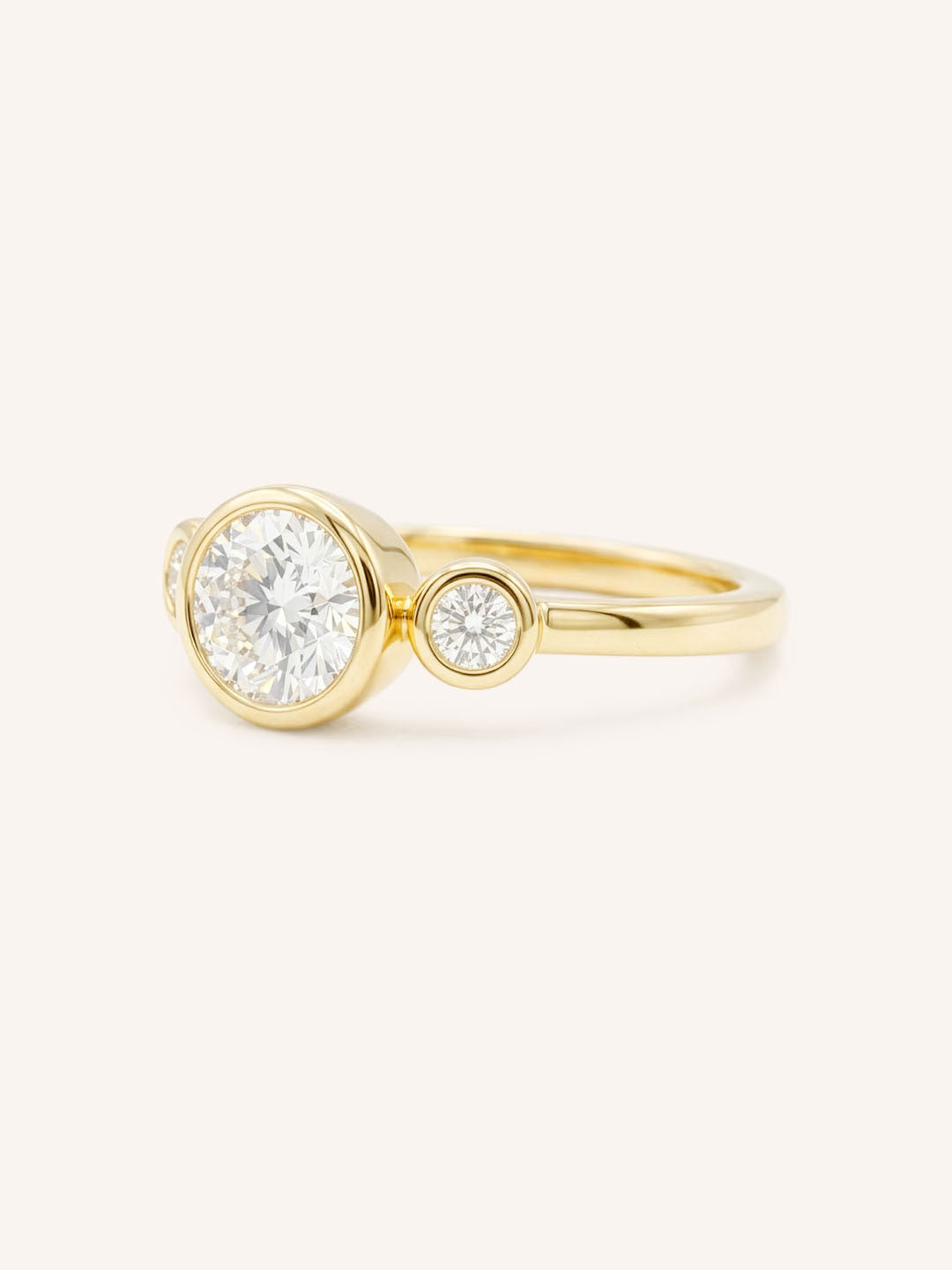Yellow Gold Tamara Round Three Stone Diamond Bezel Engagement Ring side view on white background