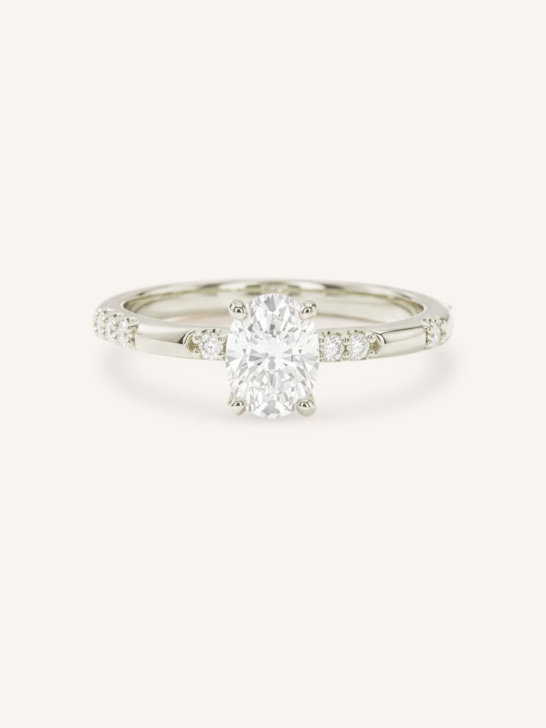 White Gold oval diamond engagement ring with accented band on white background